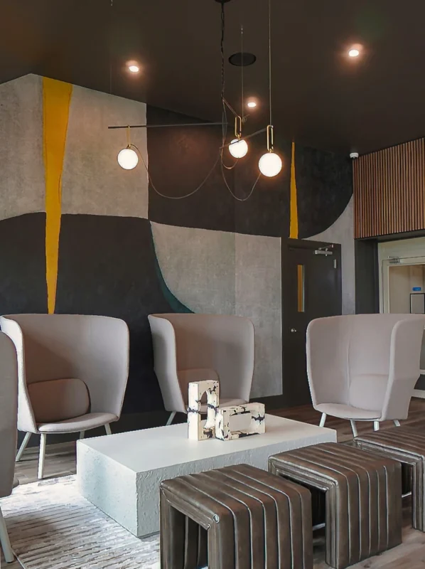 Stylish modern lounge with abstract mural, elegant seating, and inviting ambiance for gatherings.