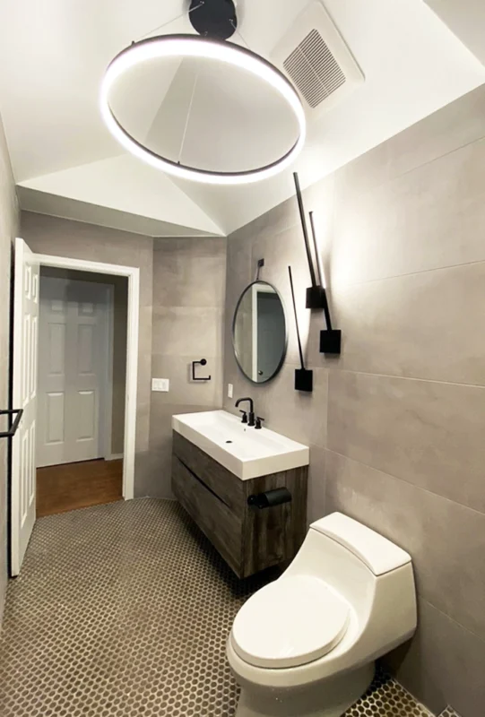 Modern minimalist bathroom featuring gray tiles, sleek vanity, and elegant fixtures for a serene retreat.