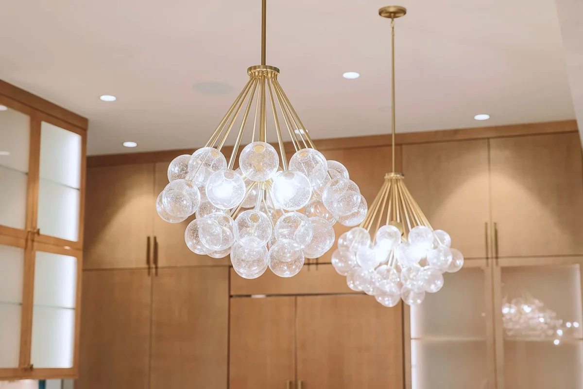 Elegant modern pendant chandeliers featuring glass spheres illuminate a stylish, contemporary interior design.