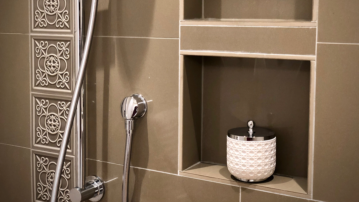 Stylish modern bathroom with chrome shower fixtures and elegant textured tiles.