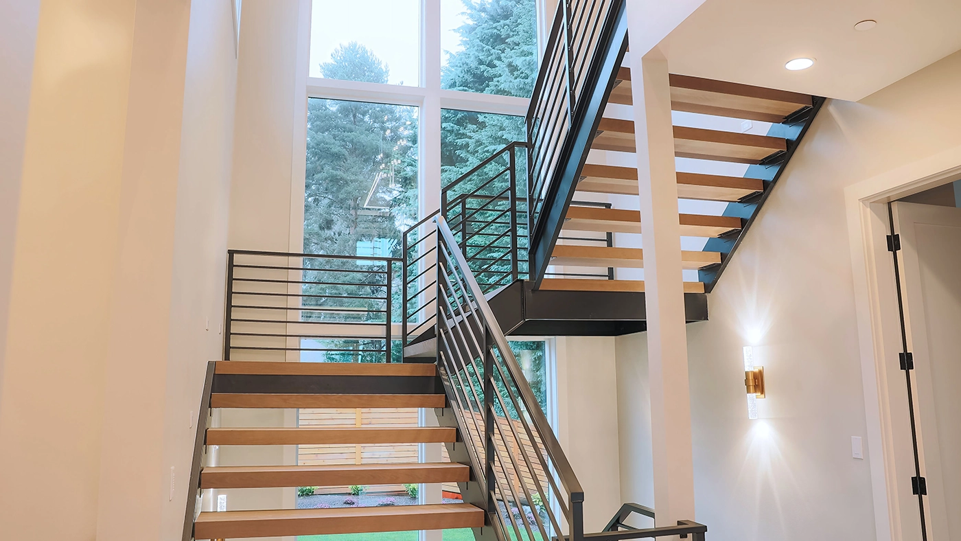 Modern staircase with wooden treads and natural light in a bright, contemporary interior.