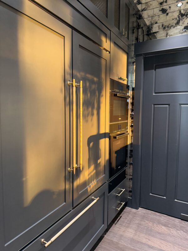 Sleek navy blue kitchen with gold accents, modern cabinetry, and minimalistic design elements.