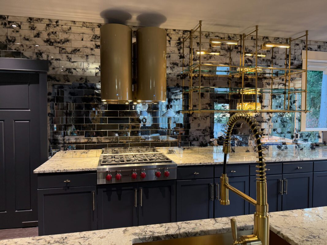 Elegant luxury modern kitchen featuring navy cabinetry, stone countertops, and dramatic mustard yellow accents.