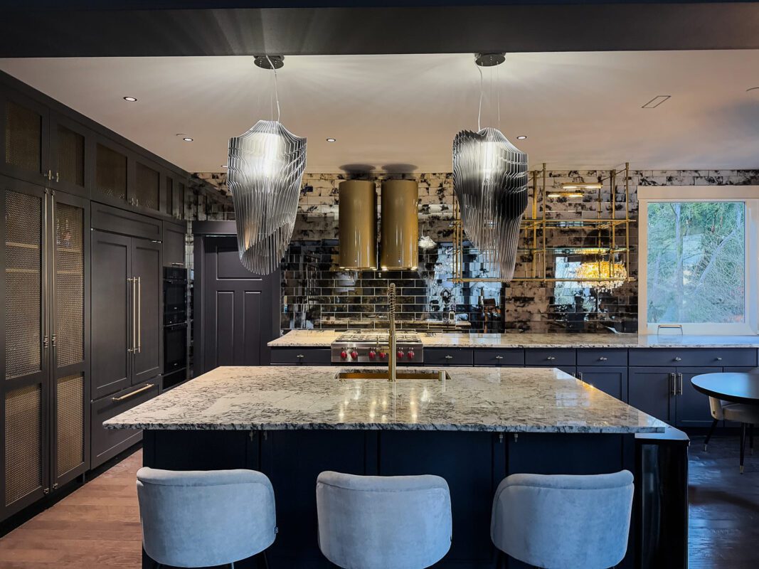 Elegant modern kitchen design featuring dark cabinetry, marble island, and unique pendant lighting.