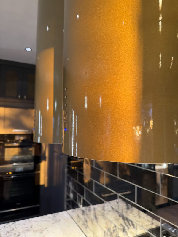 Stylish modern kitchen with gold pendant lights and elegant dark cabinetry for a luxurious look.