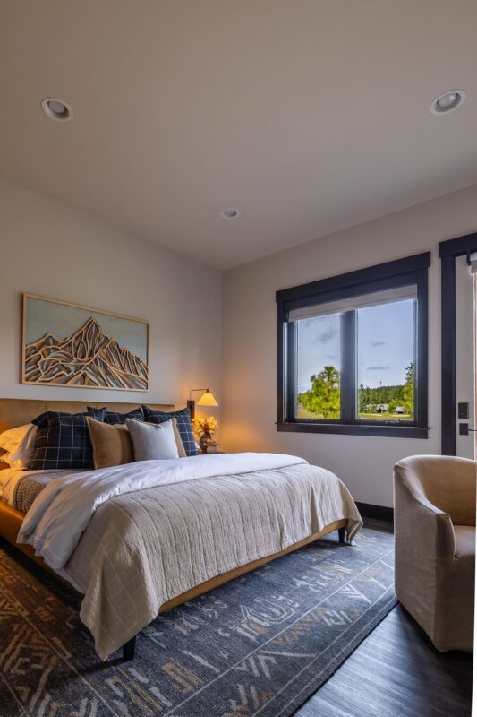 A spacious, elegantly decorated bedroom at the Suncadia Grand Retreat, showcasing luxurious furnishings, large windows, and a serene atmosphere.