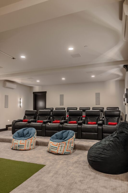 A luxurious home theater at the Suncadia Grand Retreat, featuring plush seating, large screen, surround sound, and ambient lighting.