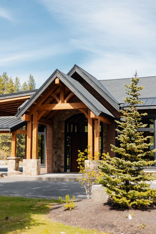 Stunning modern home entrance with natural elements, stone accents, and inviting landscaping.