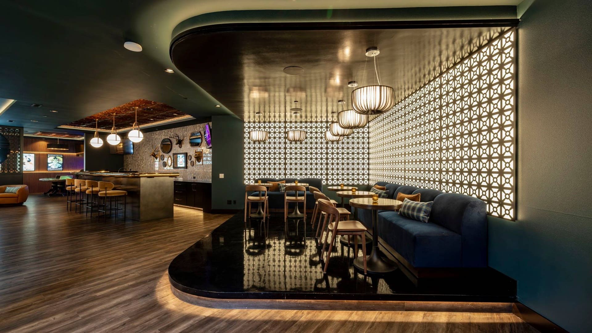 Sophisticated lounge with deep blue tones, cozy seating, and a stylish bar area.