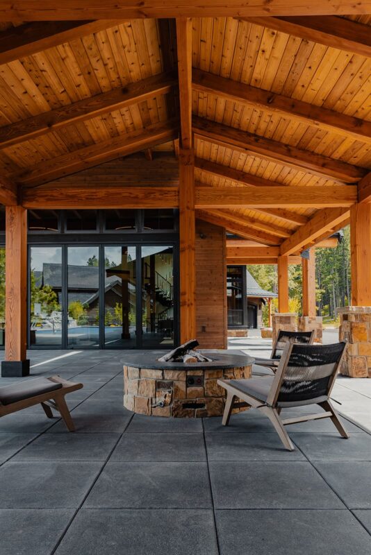 Cozy outdoor seating area with fire pit, modern chairs, and seamless indoor-outdoor connection.