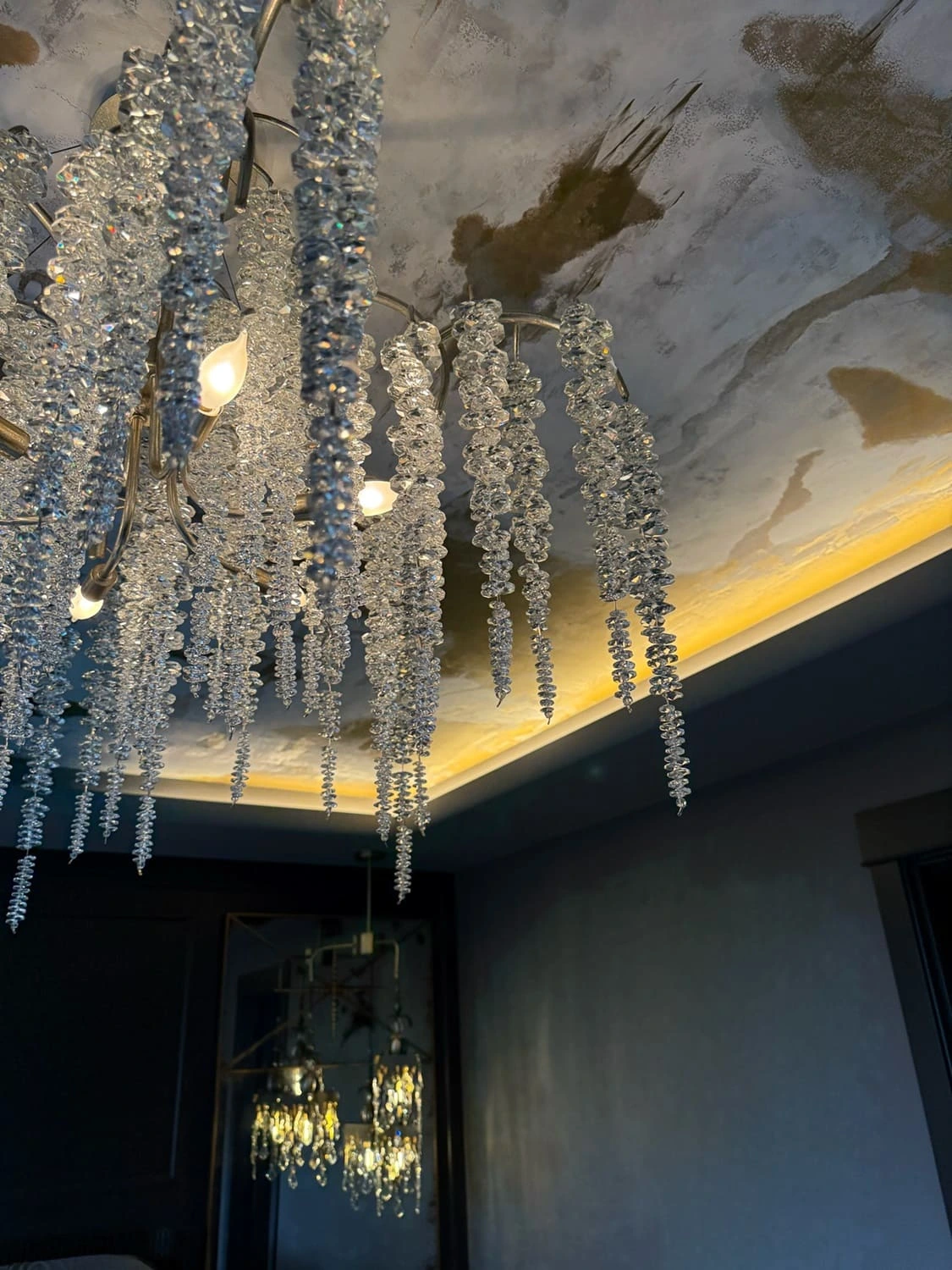 Elegant chandelier with sparkling crystals enhancing rustic decor and warm ambient lighting.