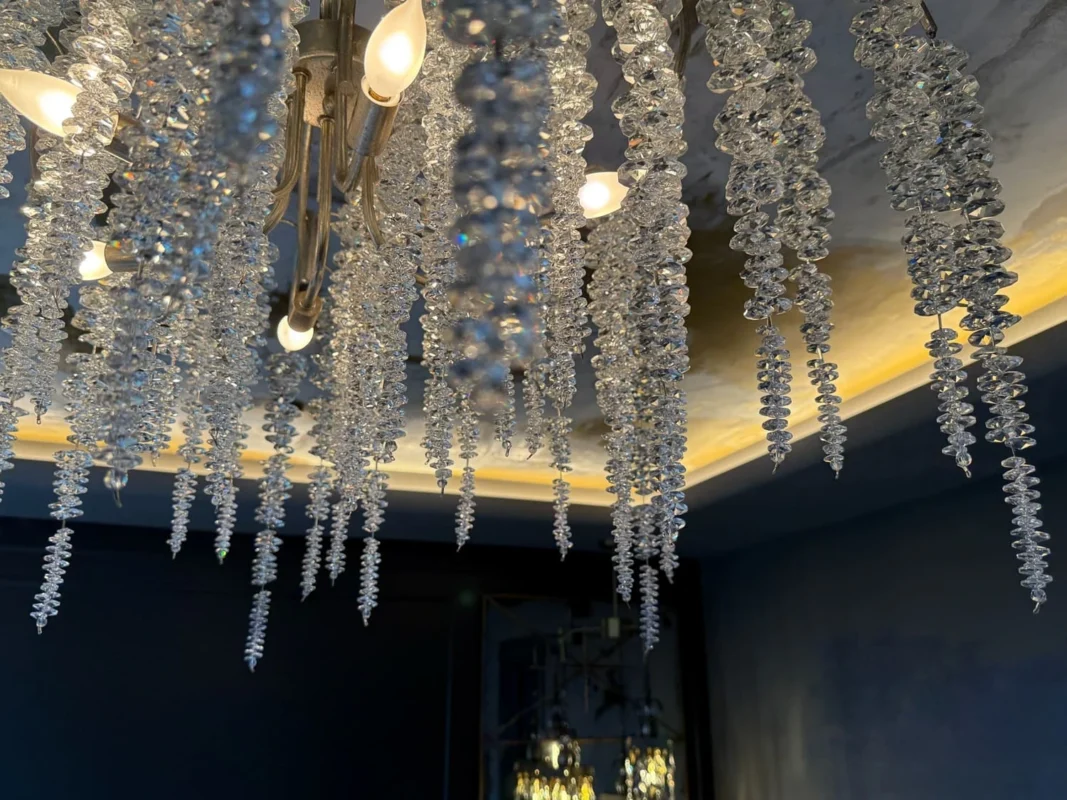 Elegant crystal chandelier illuminating a luxurious space with stunning light reflections.