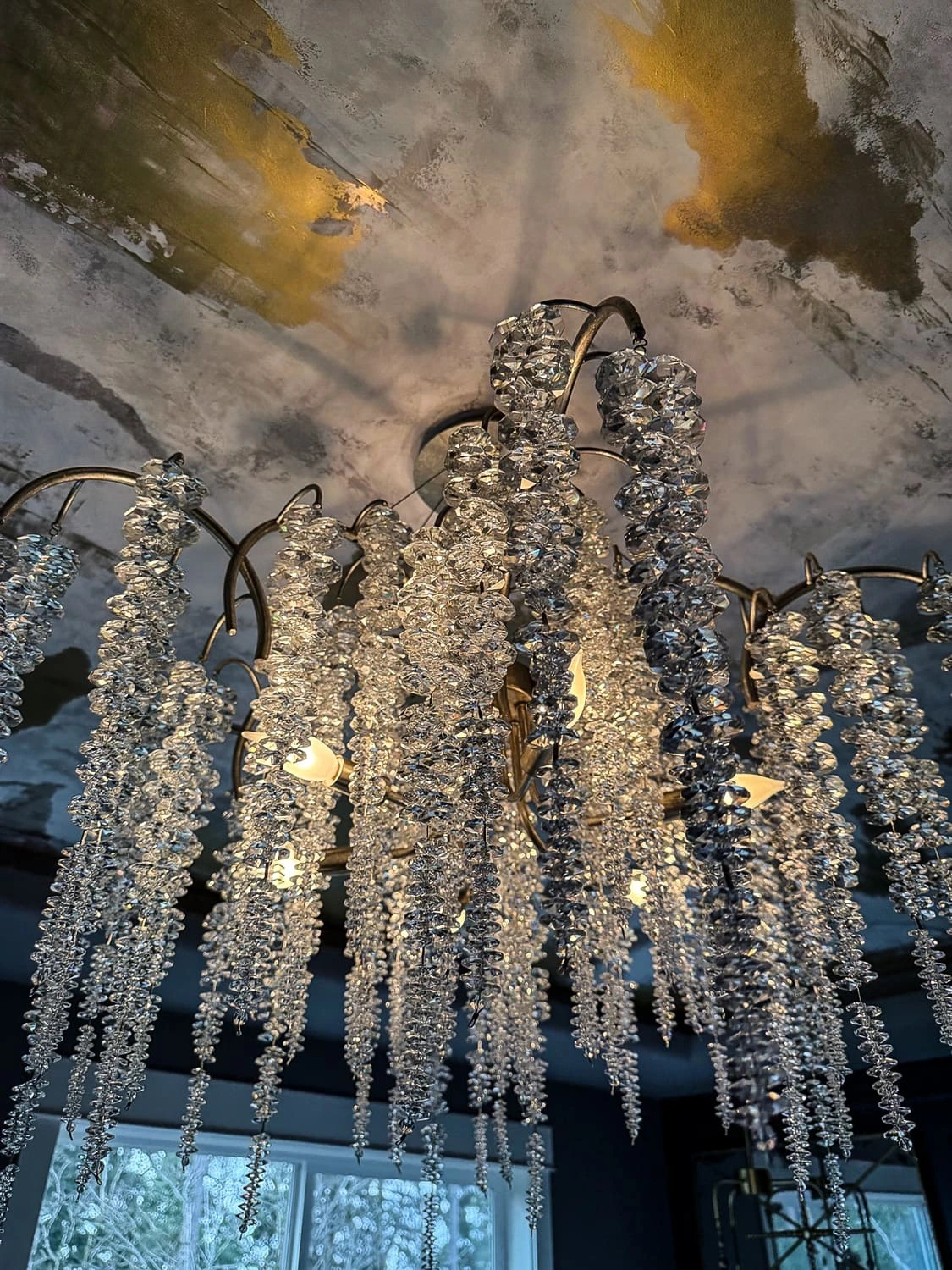 Stunning chandelier with cascading crystals enhances luxurious interior design and warm ambiance.