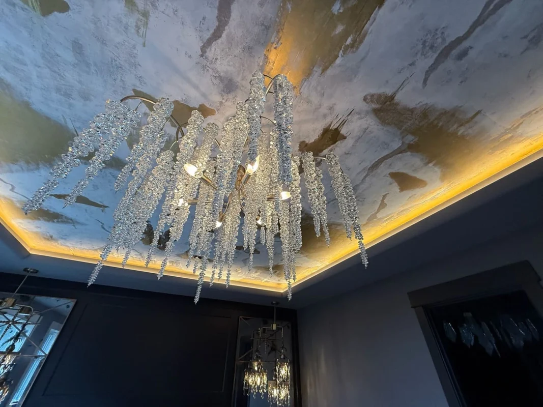 Elegant chandelier with crystal strands enhances luxurious interior lighting and ambiance.