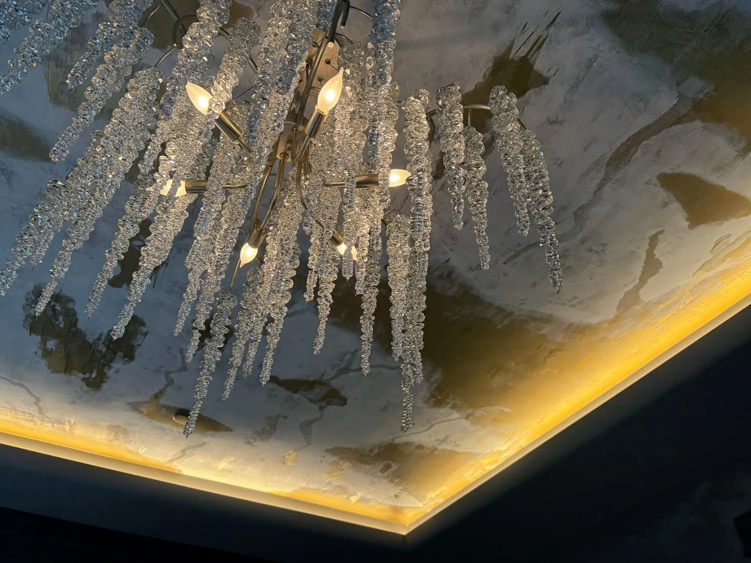 Sophisticated chandelier with icicle glass pendants adds elegance to modern interior design.