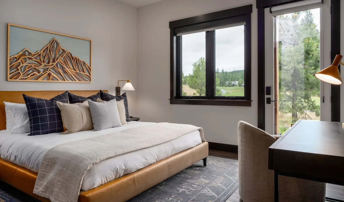 Modern serene bedroom design featuring a cozy bed, natural light, and rustic decor elements.