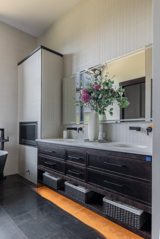 Contemporary Suncadia bathroom shower showcasing under-bench LED lighting, recessed product niche, and soft neutral tiles for a calm spa atmosphere.