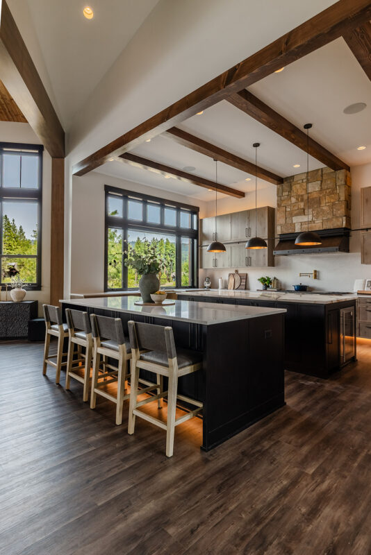 Luxury black and wood kitchen island design with seating for four and soft amber accent lighting.