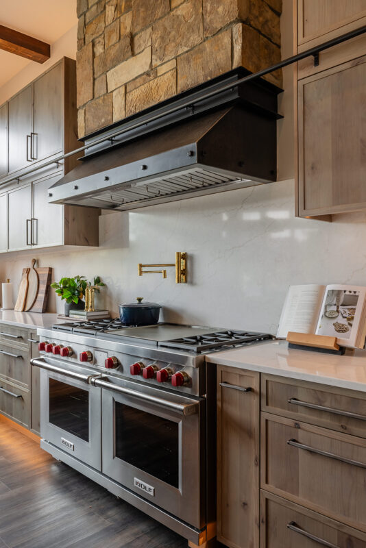 Suncadia great room view showing open kitchen layout, stone fireplace, and cohesive interior styling by Ariana Designs & Interiors.